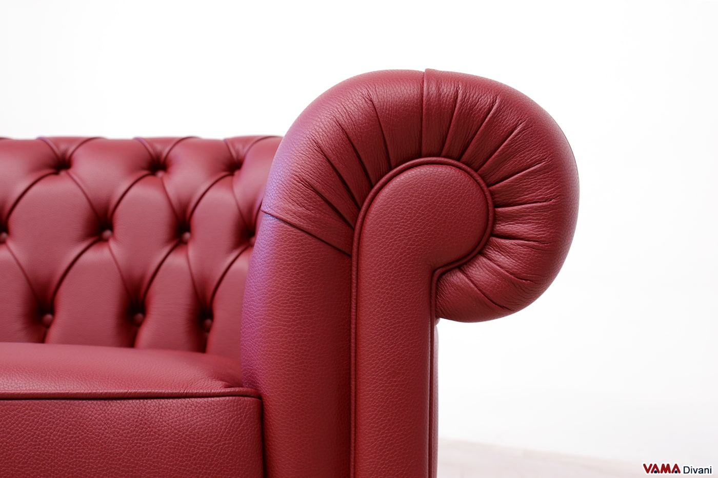 Détail accoudoir canapé Chesterfield cuir épais bordeaux