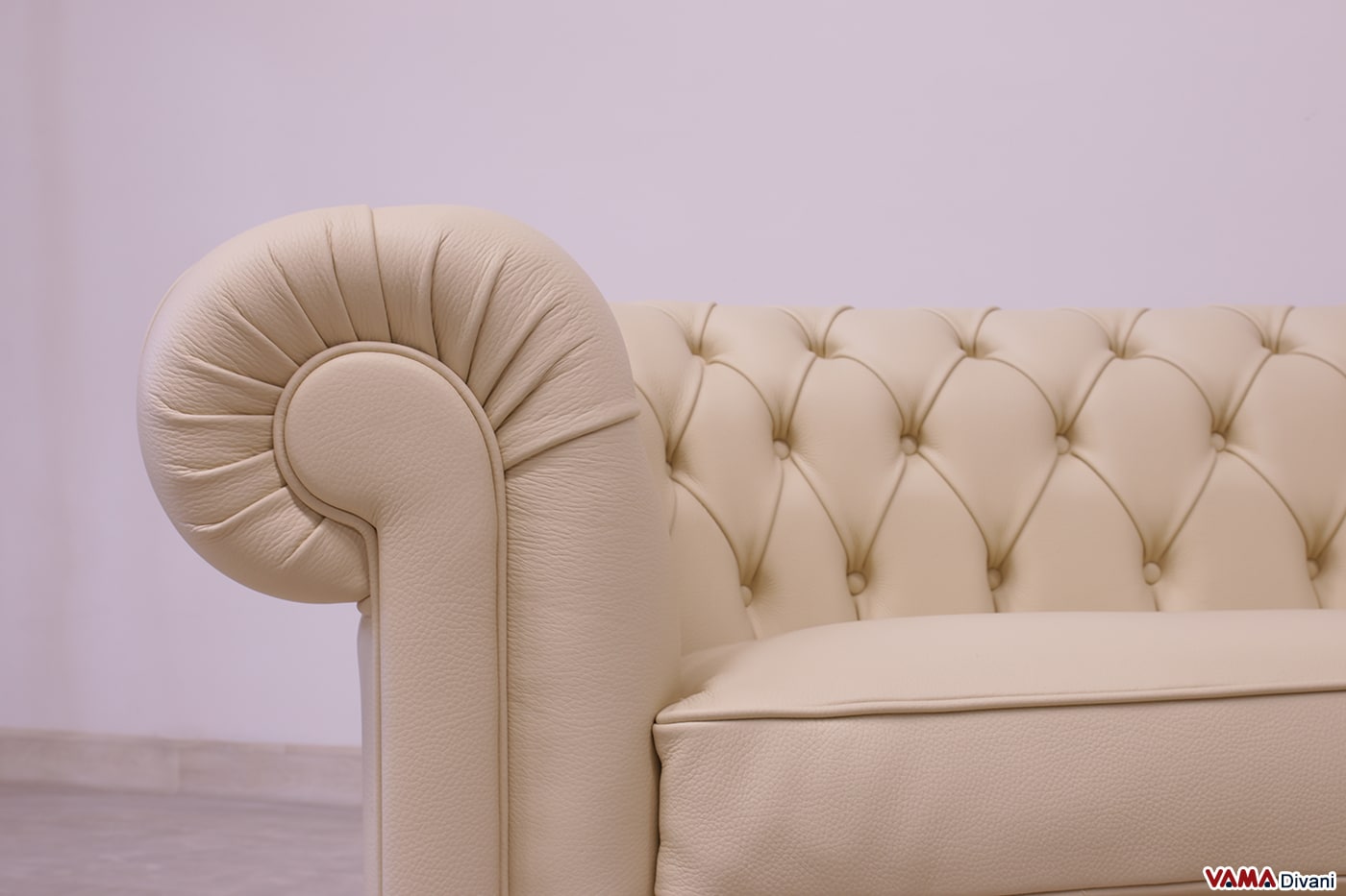 Détail frontal de l'accoudoir du canapé Chesterfield en cuir beige